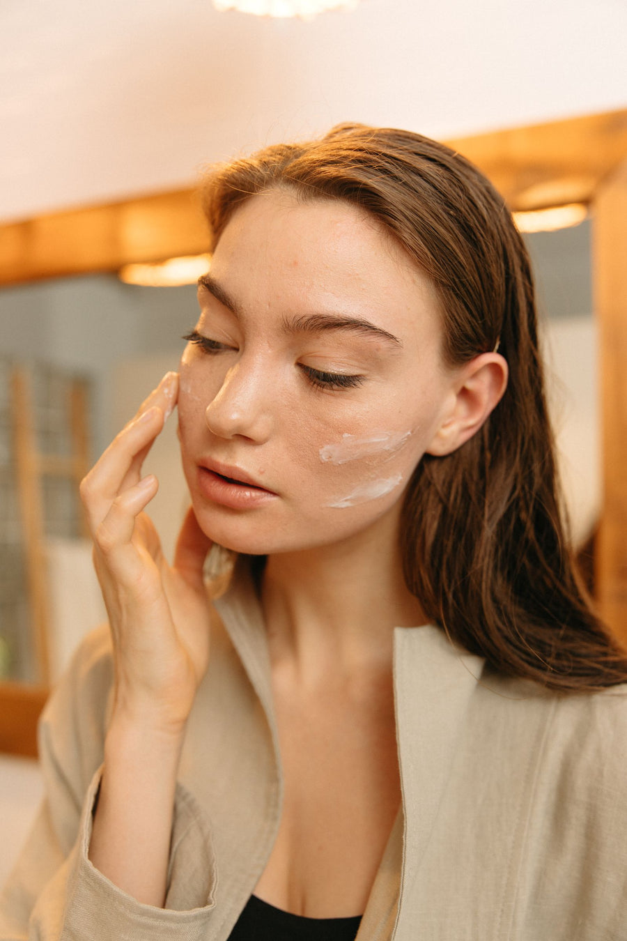 Mujer aplicando crema hidratante facial durante su rutina diaria de cuidado de la piel